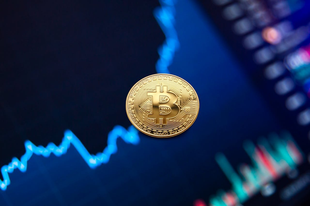 about-us-02 A gold Bitcoin coin against a backdrop of a digital financial chart, symbolizing cryptocurrency trading.